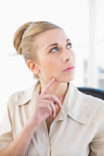 Thoughtful young blonde businesswoman looking up — Stock Photo, Image