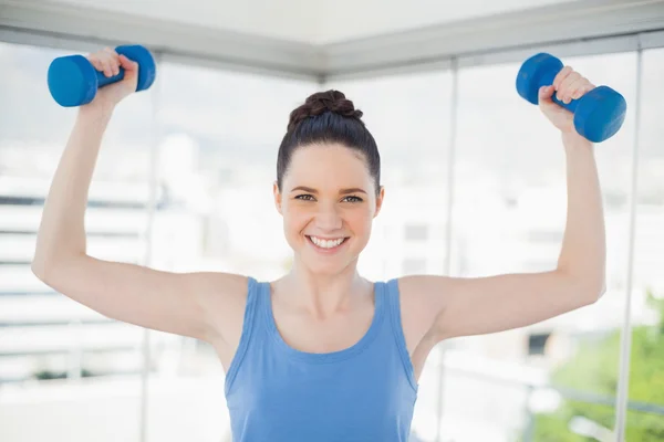 Lächelnde, fitte Frau, die mit Hanteln trainiert — Stockfoto