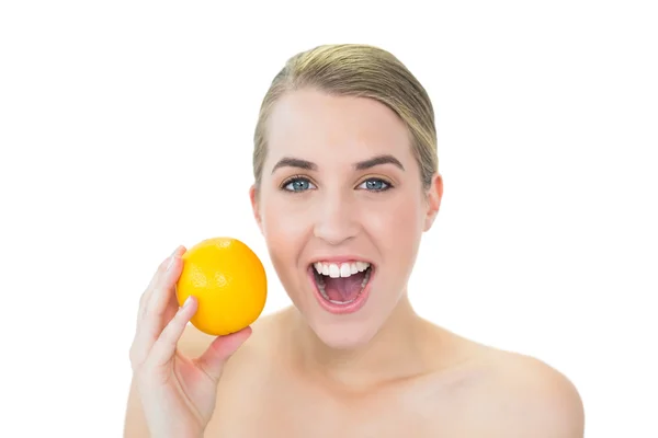 Surprised attractive blonde holding orange — Stock Photo, Image