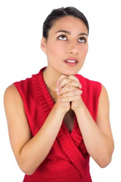 Beautiful brunette in red dress praying — Stock Photo, Image