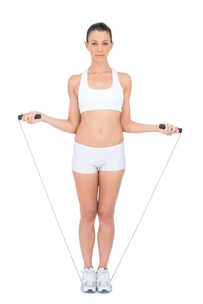 Mujer seria en ropa deportiva haciendo ejercicio con saltar la cuerda —  Fotos de Stock