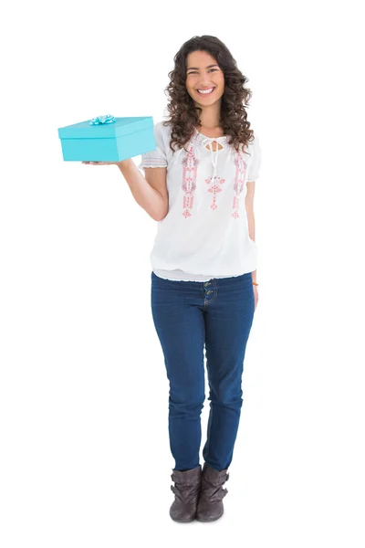 Cheerful casual brunette holding a present — Stock Photo, Image