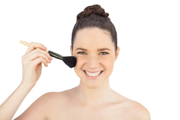 Modèle sensuel souriant à l'aide d'une brosse à blusher — Photo