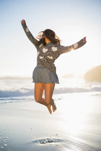 Mujer elegante saltando en la playa — Foto de Stock