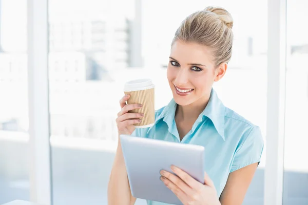 Glimlachend stijlvolle vrouw met behulp van Tablet PC houden van koffie — Stockfoto