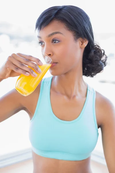 Mujer en forma meditativa bebiendo un vaso de jugo de naranja —  Fotos de Stock