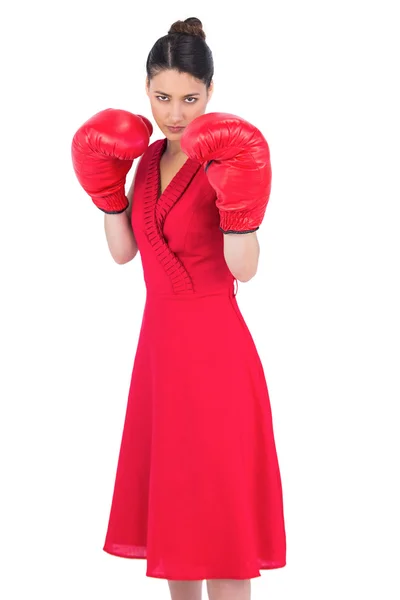 Elegant brunette in red dress wearing boxing gloves — Stock Photo, Image
