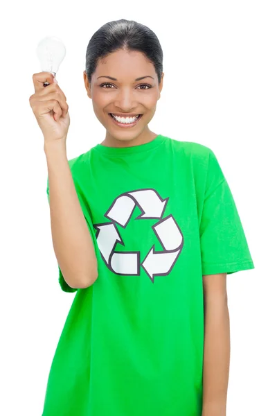 Happy model wearing recycling tshirt holding light bulb — Stock Photo, Image