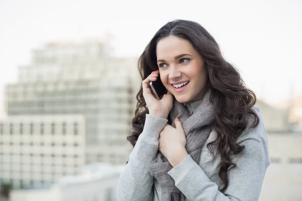 Веселая красивая брюнетка в зимней одежде, разговаривающая по телефону. — стоковое фото
