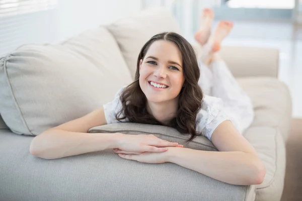 Sorridente bella donna sdraiata su un accogliente divano — Foto Stock