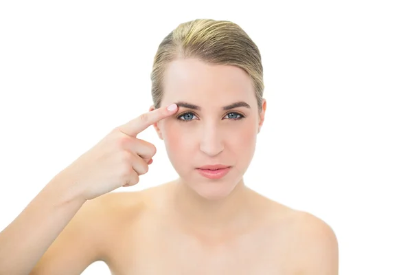 Pretty blonde pointing at her eyebrow — Stock Photo, Image