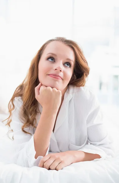 Nachdenkliche hübsche Frau liegt auf ihrem Bett — Stockfoto