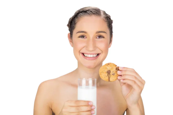 Cheerful young model holding cookie and milk — Stock Photo, Image