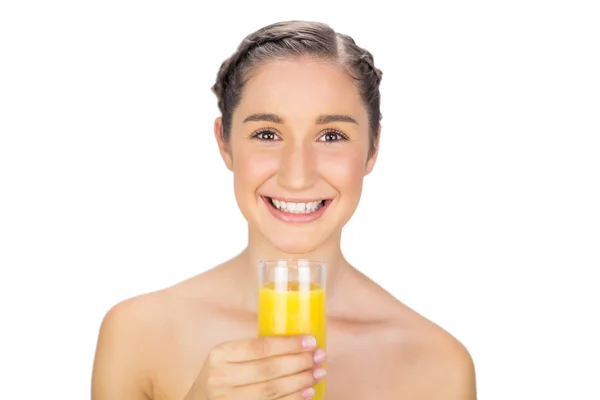 Modelo lindo sorrindo segurando vidro de suco de laranja — Fotografia de Stock