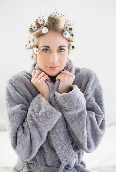 Lovely relaxed blonde woman in hair curlers looking at camera — Stock Photo, Image
