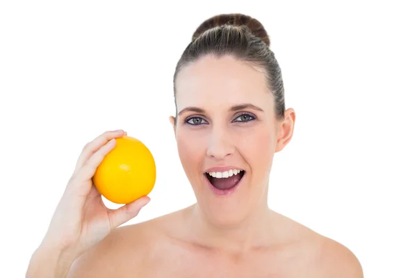 Surpreendido linda mulher segurando laranja — Fotografia de Stock