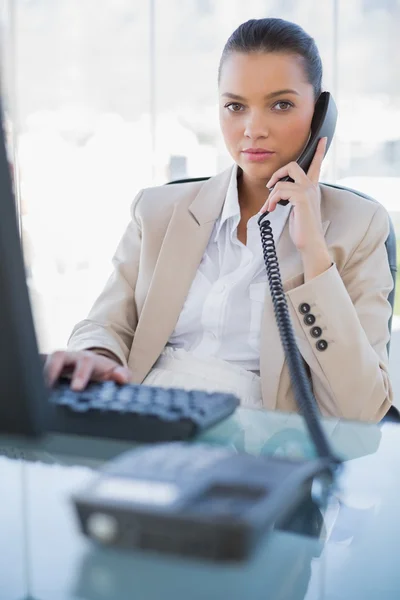 Ernstige prachtige zakenvrouw beantwoorden de telefoon — Stockfoto