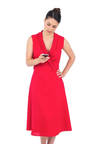 Morena elegante em vestido vermelho enviando mensagem de texto — Fotografia de Stock