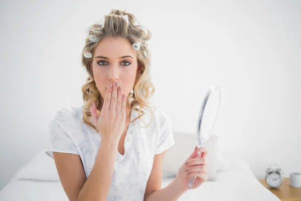 Nádherná blondýna nosí natáčky na vlasy jí ucpal ústa — Stock fotografie