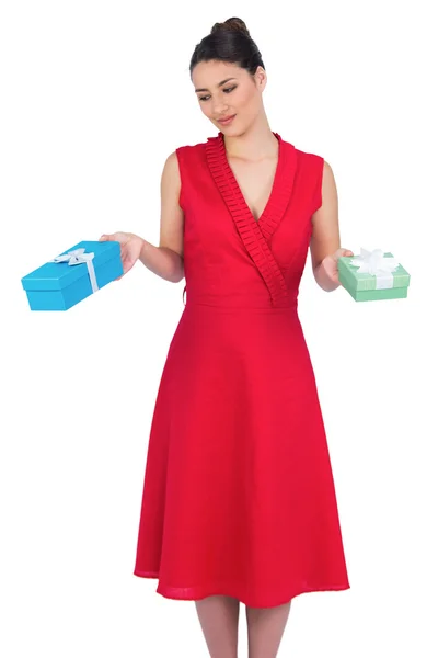 Content glamorous model in red dress offering presents — Stock Photo, Image