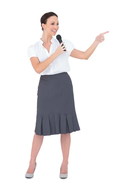 Attractive presenter holding microphone pointing — Stock Photo, Image