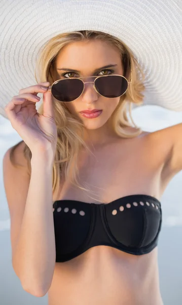 Hermosa rubia en elegante bikini negro mirando por encima de sus gafas de sol — Foto de Stock