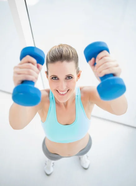 Mujer sonriente haciendo ejercicio con pesas — Foto de Stock