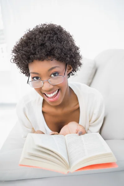 Smiling gorgeous brunette reading book Stock Photo