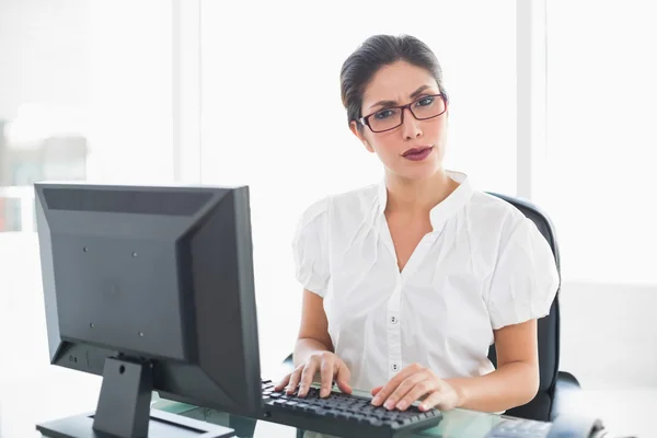 Serious businesswoman working at her desk looking at camera — Stock Photo, Image