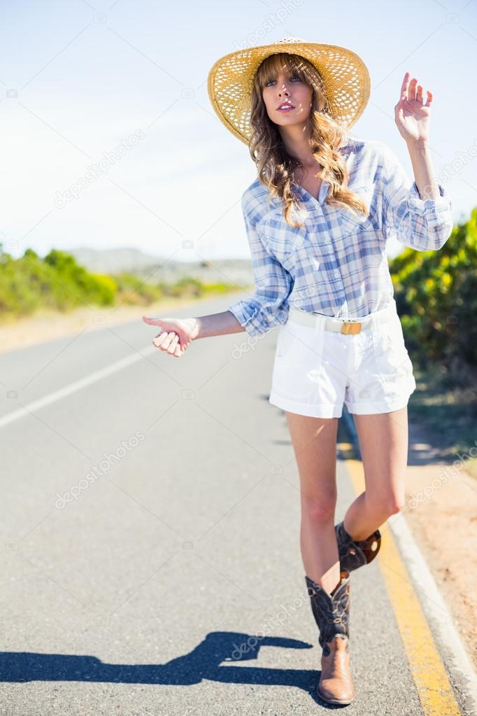 Attractive blonde hitchhiking at the roadside