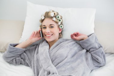 cep telefonu ile arama saç curlers içinde rahat sevimli sarışın kadın
