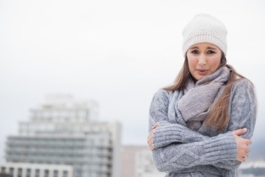 Shivering cute brunette with winter clothes on posing clipart