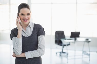 telefon poz üzerinde gülümseyen iş kadını