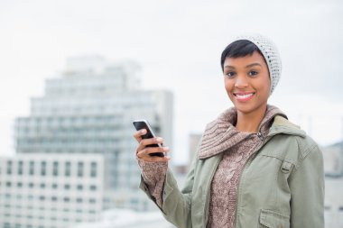 neşeli genç model cep telefonu tutan kış giysileri içinde