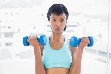 dumbell tutan papatyanın siyah saçlı kadın