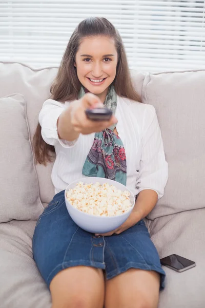 Smiling cute model changing tv channel — Stock Photo, Image
