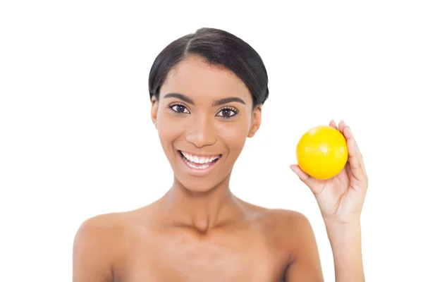 Uśmiechający się atrakcyjny model posiadający pomarańczowy — Zdjęcie stockowe