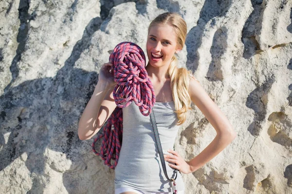 岩で傾いている登山装備を保持している女性の笑みを浮かべてください。 — ストック写真