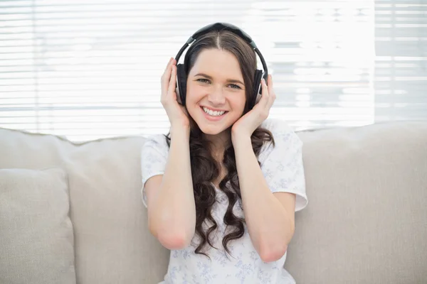 Smiling young woman listening to music — Stock Photo, Image