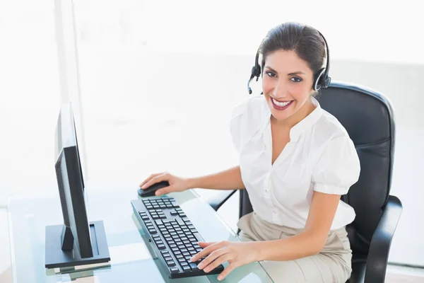 Agent joyeux du centre d'appels travaillant sur ordinateur pendant un appel — Photo