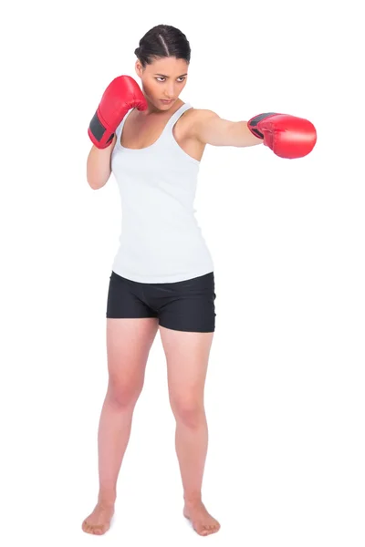 Slender model with boxing gloves punching — Zdjęcie stockowe