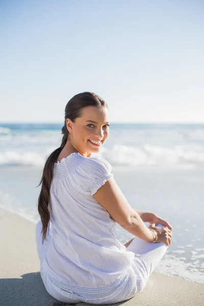 Vista posteriore della donna sorridente sulla spiaggia guardando oltre le spalle — Foto Stock