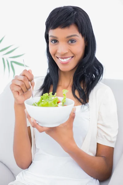 Seductive black haired woman in white clothes eating salad — Stock Photo, Image