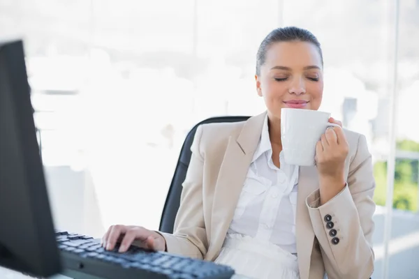 Sorrindo sofisticada empresária cheirando café — Fotografia de Stock