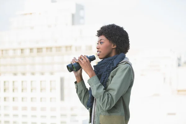 Curious casual model holding binoculars — Stock Photo, Image