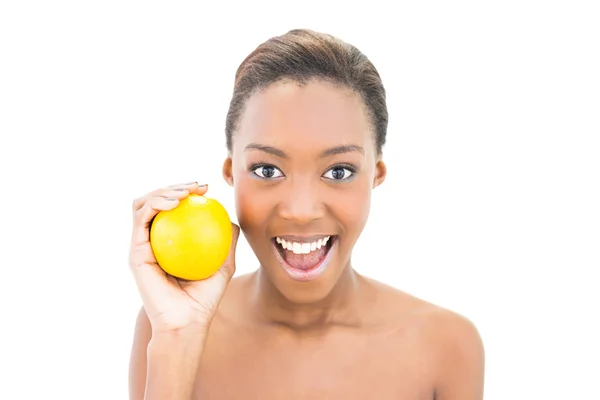 Sonriente hermosa modelo sosteniendo naranja — Foto de Stock