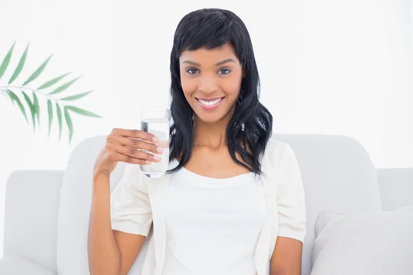 Contenu femme aux cheveux noirs en vêtements blancs tenant un verre d'eau — Photo