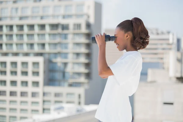 Side view of pretty woman using binoculars — Stock Photo, Image
