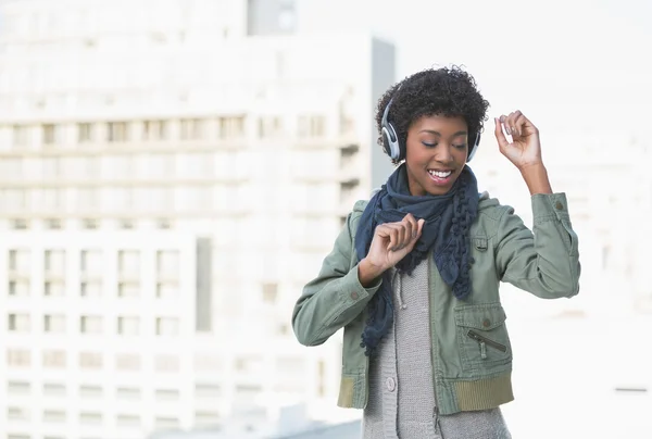 Glimlachend casual model dansen terwijl u luistert naar muziek — Stockfoto