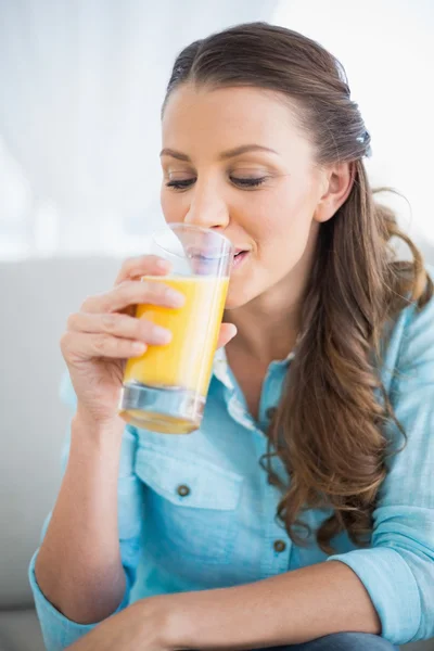 Szczęśliwa kobieta pije sok pomarańczowy — Zdjęcie stockowe